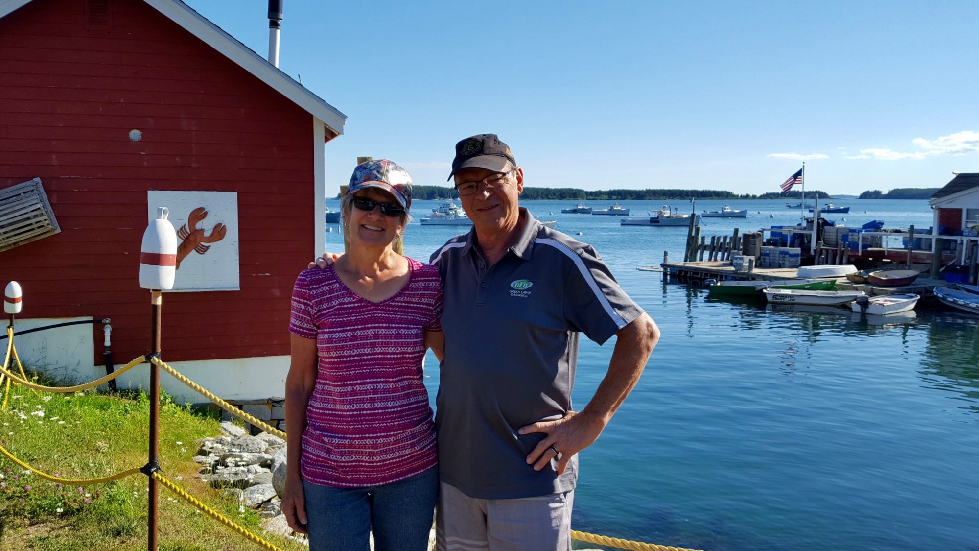 Image of older couple standing next to a small harbor in Maine