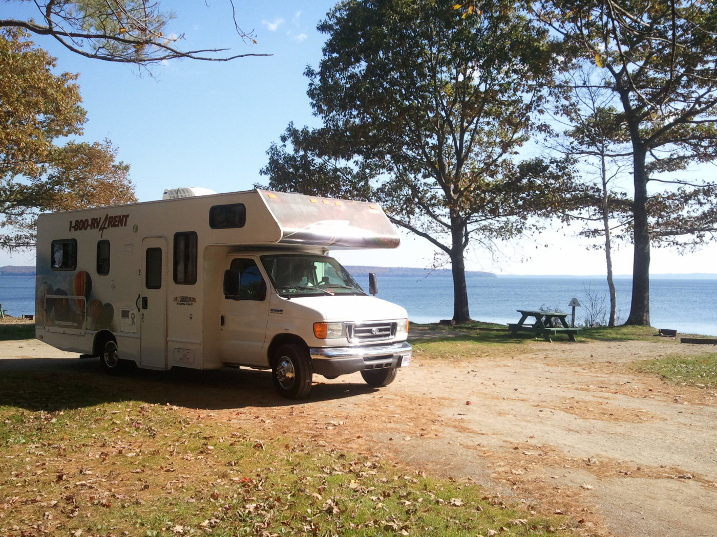Image of recreational vehicle next to lake in late summer