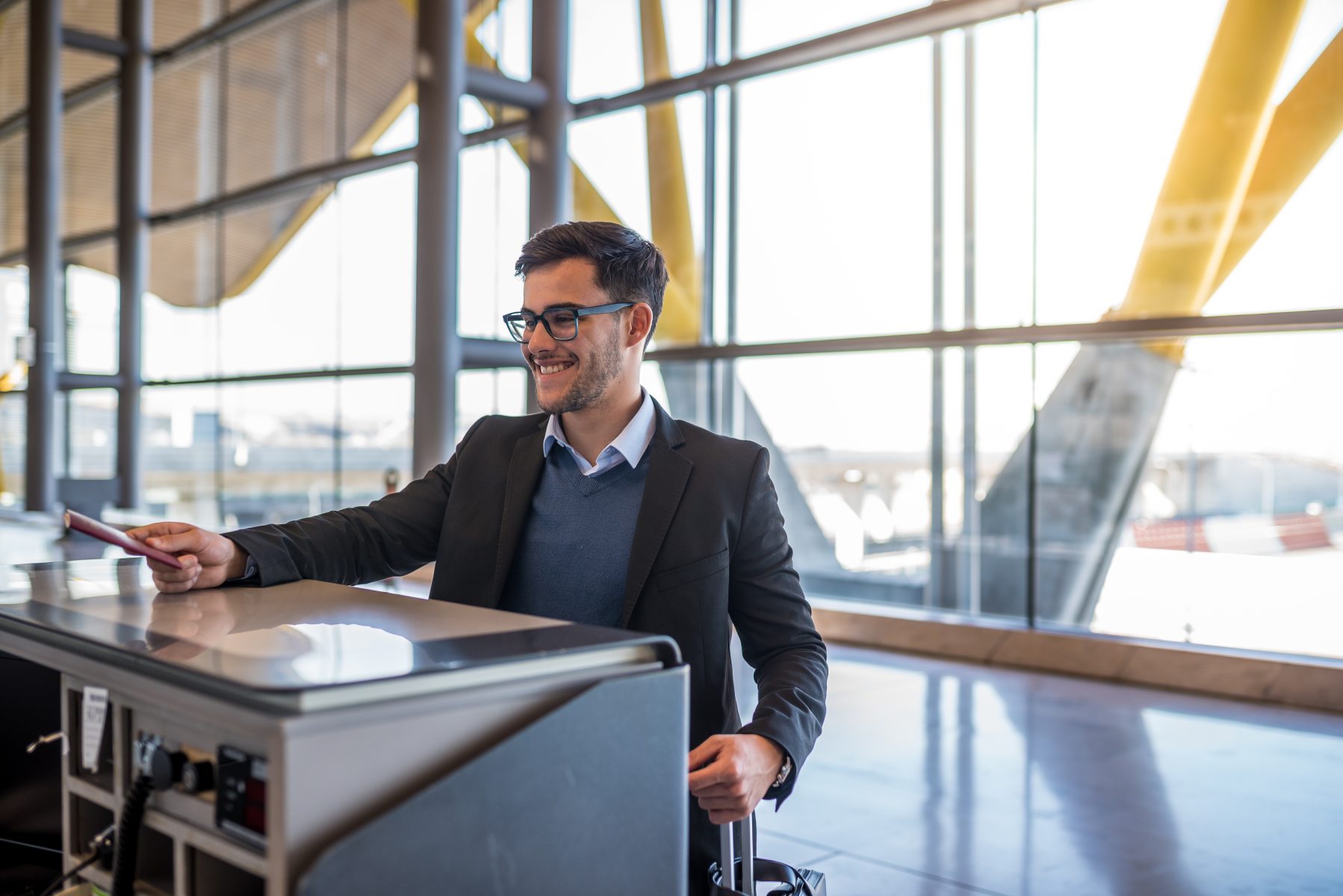 attractive young man check-in at the airport with his passport
