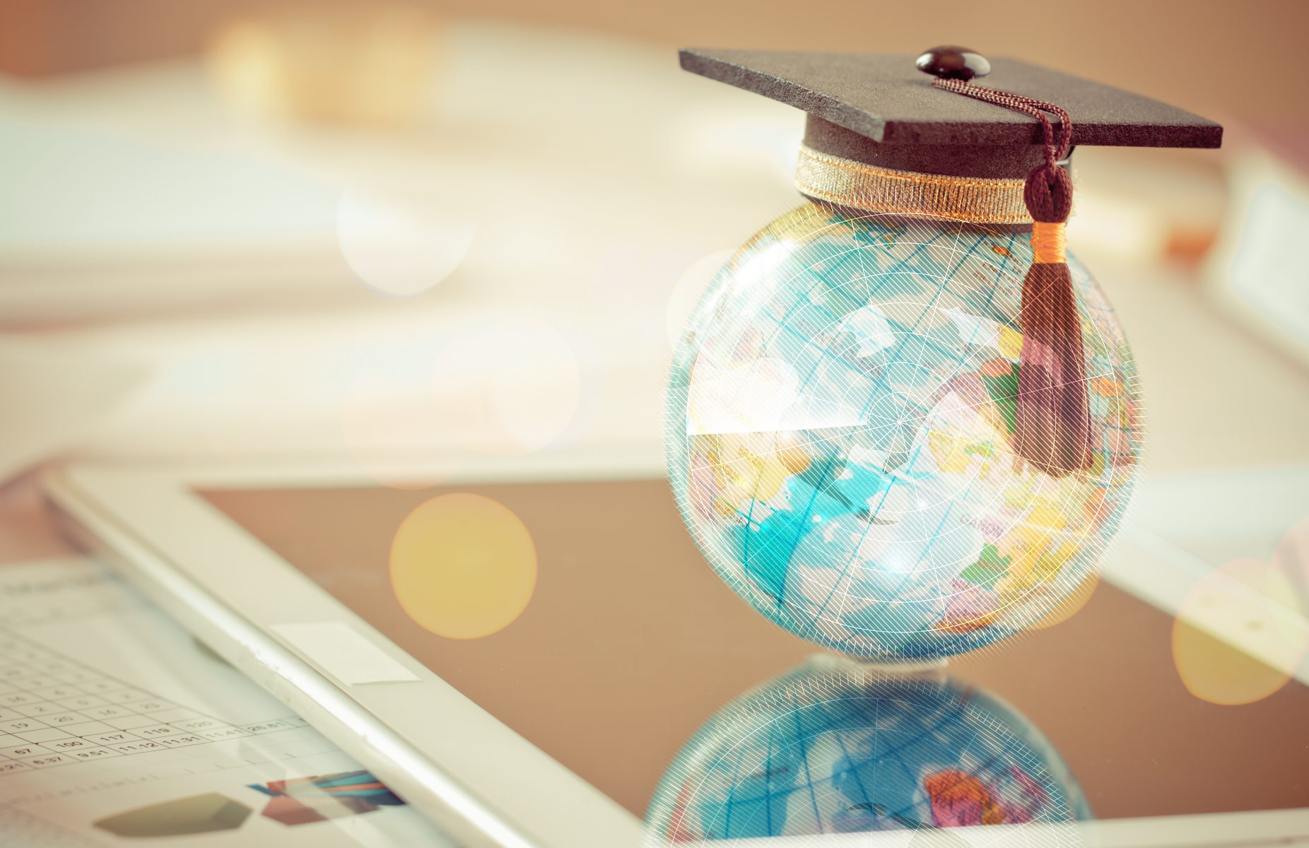 Picture of globe with graduation cap on top. 