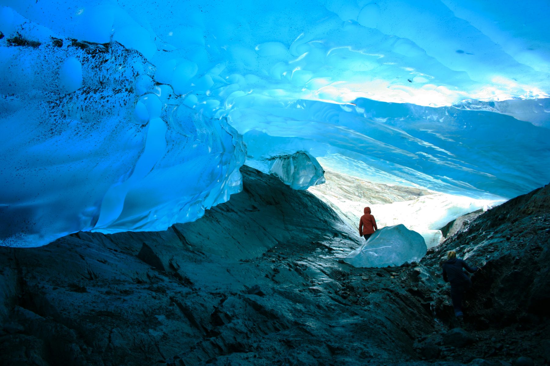 Man exploring inside of cave under Mendenhall Glacier in Alaska