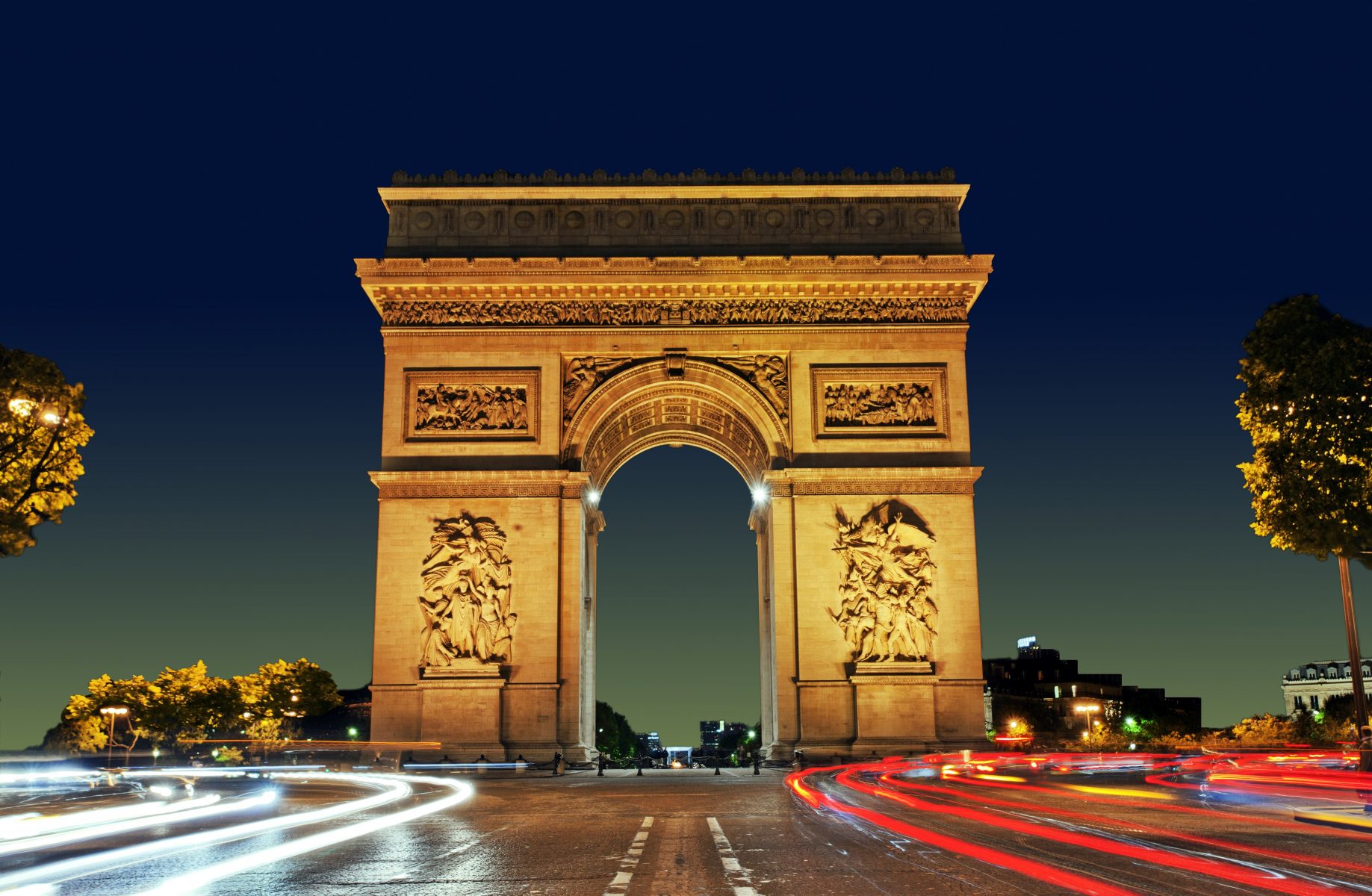 Arc de Triomphe with passing cars at night