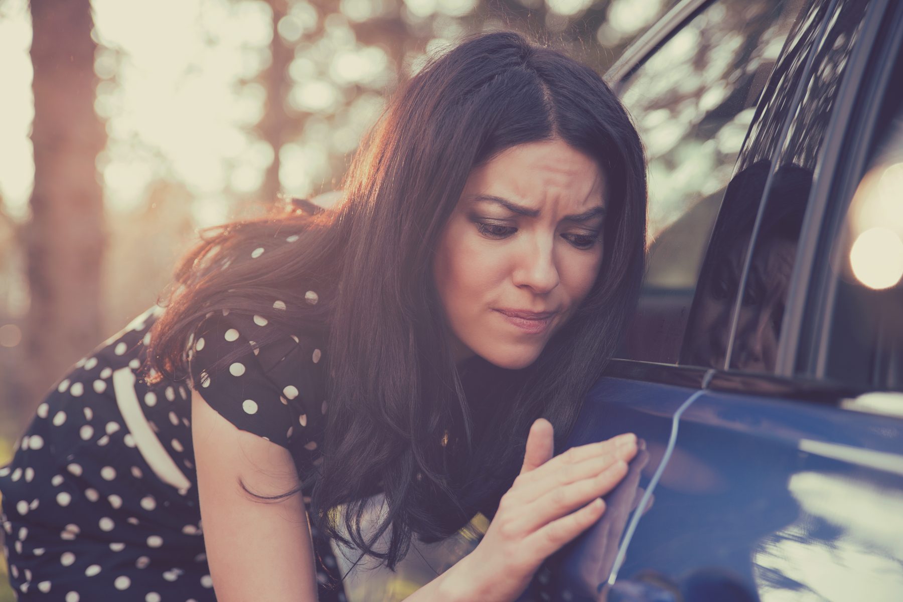 Young Woman Inspecting Car Rental Blemish