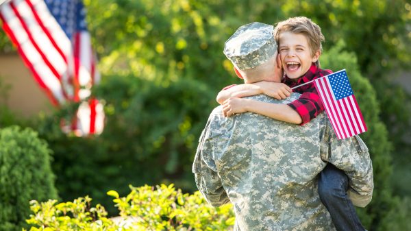 Military dad hugging their child